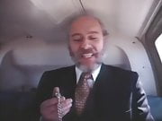 Old bearded man in a suit getting head in a helicopter