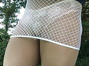 Close up of white panties under fishnet mini .