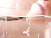 Close-up cumshot of circumcised cock in water