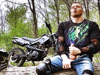 Handsome Biker While Riding A Motorcycle Forest And...